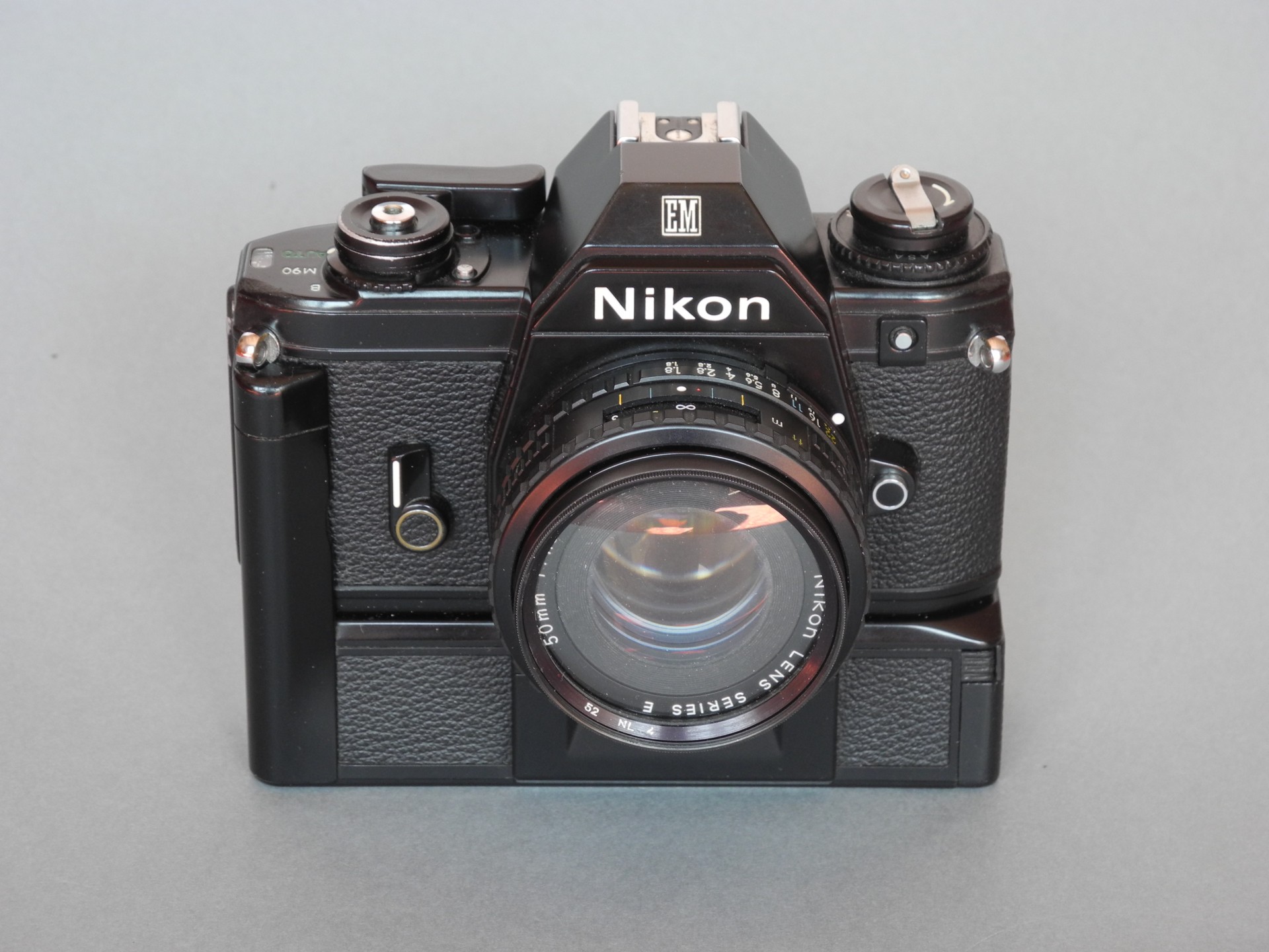 *Nikon EM1979 (gainage façon cuir) petit bouton argenté en facade*